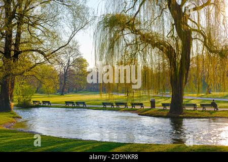 Personne seule sur des bancs de parc désertés à Schwabinger Bach, Englischer Garten, Munich, haute-Bavière, Bavière, Allemagne Banque D'Images