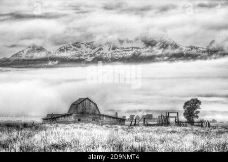 L'ancienne grange en rondins de la ferme John Molton sur la rangée Mormon dans le parc national de Grand Teton avec la chaîne Teton derrière. Wyoming, États-Unis. Banque D'Images