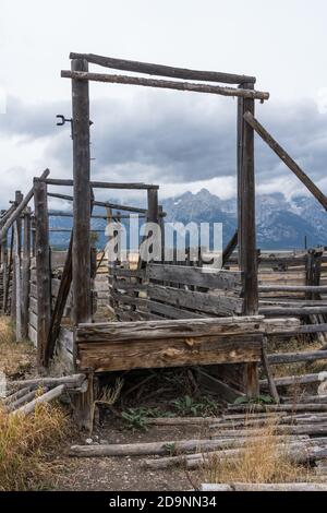 La rampe de chargement en bois et les coraux sur la propriété John Molton sur Mormon Row dans le parc national de Grand Teton avec la chaîne de Tetons derrière. Wyoming, Banque D'Images