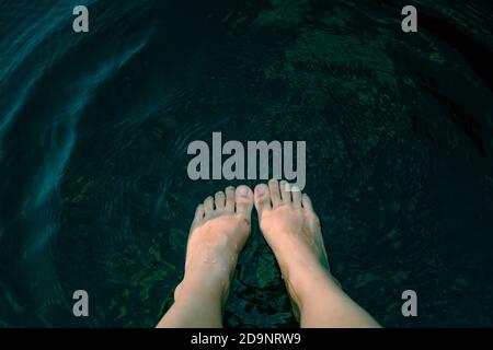 Les pieds de la femme dans l'eau de la rivière Banque D'Images