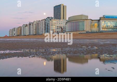 Horizon d'Ostende (Ostende) avec plage de la mer du Nord au coucher du soleil et pleine lune de réflexion, Belgique. Banque D'Images