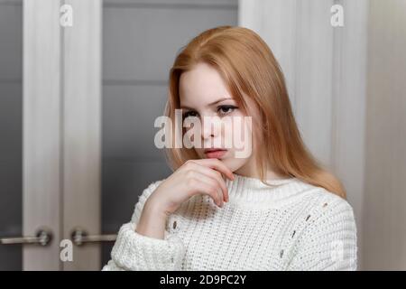 portrait d'une triste belle fille caucasienne de 16 ans dans un pull blanc tricoté Banque D'Images