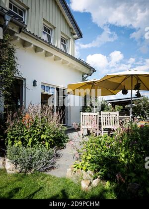 Maison de campagne avec lits de fleurs colorés et mobilier Banque D'Images