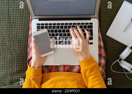 Achats en ligne. Femme saisissant le code et le mot de passe du message sur le téléphone de l'ordinateur portable. Banque D'Images