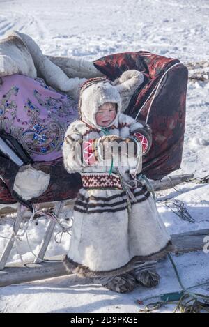 Une jeune fille de Nenet en tenue traditionnelle jouant avec un
