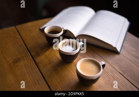 3 tasses d'espresso - macchiatto, espresso. Photo du café-restaurant. Café et un livre - une photo de café Banque D'Images