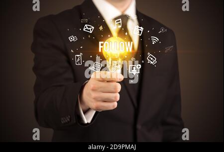 Homme d'affaires tenant une ampoule avec L'inscription CI-DESSOUS, concept de médias sociaux Banque D'Images