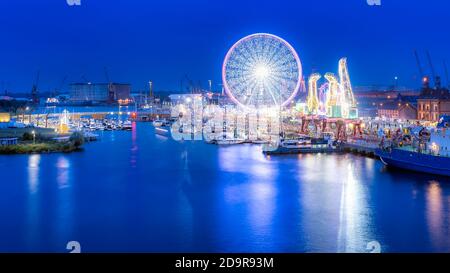 Des navires, des grues appelées Dzwigozaury et un parc d'attractions à Odra River Boulevards à Szczecin. La foule profite des journées de la mer. Photo nocturne à exposition longue Banque D'Images