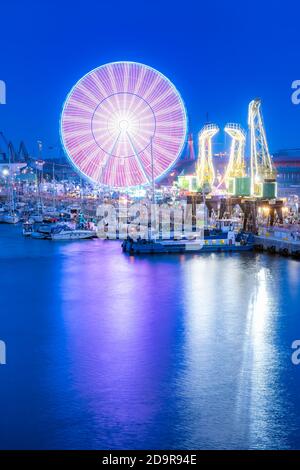 Des navires, des grues appelées Dzwigozaury et un parc d'attractions à Odra River Boulevards à Szczecin. La foule profite des journées de la mer. Photo nocturne à exposition longue Banque D'Images