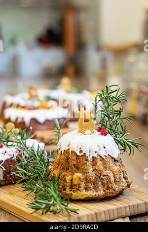 Gâteau aux fruits de Noël, pudding décoré de biscuits au pain d'épice, romarin et baies de lingonis sur bois. Dessert de Noël traditionnel fait maison. Banque D'Images