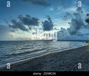 Paysage avec nuages de tempête sur la plage du lac, tourné dans la lumière du coucher du soleil à Bolsena, Viterbo, Italie Banque D'Images