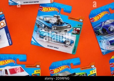 Ukraine, Kiev - février 28. 2020: Le groupe de la collection de jouets coloré de voiture sur fond orange. Hot Wheels. Vue de dessus. Banque D'Images