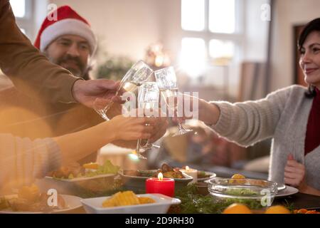 Deux couples se trinking avec des flûtes de champagne sur une table de fête au dîner Banque D'Images