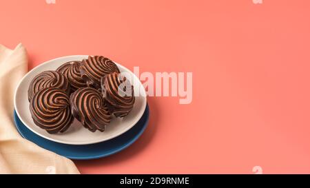 Guimauves traditionnelles à la vanille russe, glaçure au chocolat, assiettes blanches et bleues sur fond rose. Linge de table et linge de maison colorés. Station santé Copy Banque D'Images