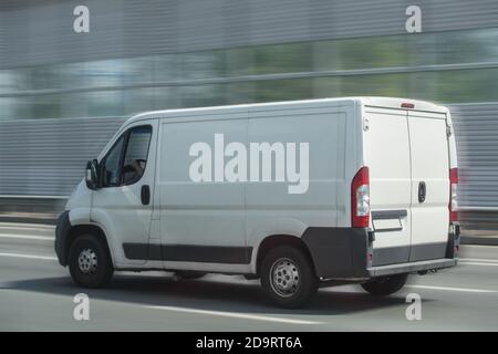 Minibus blanc va sur la ville street Banque D'Images