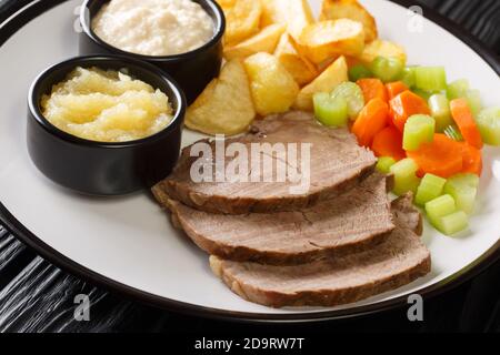 Le Tafelspitz est un plat viennois populaire fait de bœuf lentement cuit avec des légumes, du raifort et de la compote de pommes sur une assiette sur la table. Horizon Banque D'Images