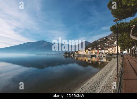 L'eau calme du lac reflète les maisons colorées de Le village romantique sur un clair jour d'hiver.vacances de Noël sur Lac de Côme, Lombardie, lak italien Banque D'Images