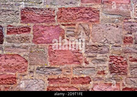 Un mur de grès, montrant un patchwork de différents types de grès utilisés dans sa construction et les différents taux d'altération et d'érosion. Banque D'Images