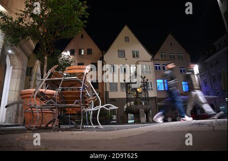 Stuttgart, Allemagne. 07th nov. 2020. Deux personnes passent par le Hans-im-Glück-Brunnen, une place autour de laquelle se trouvent de nombreux pubs et restaurants. Depuis le 2 novembre, il y a un verrouillage partiel, probablement limité à novembre. Bien que les détaillants soient toujours autorisés à rester ouverts, les restaurants et autres établissements devront fermer - s'ils n'offrent pas de nourriture à emporter. Credit: Sebastian Gollnow/dpa/Alay Live News Banque D'Images