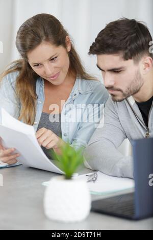 couple regardant et pointant vers le catalogue Banque D'Images