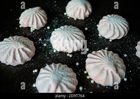 Guimauve rose sur fond sombre. Guimauves ou zephyr maison, blanches et roses. La vue du dessus. Mise au point sélective Banque D'Images