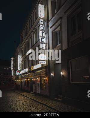 Panneau fluorescent blanc au néon indiquant « Hotel » à la lumière rouge de Hambourg district Banque D'Images