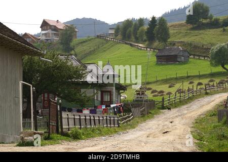 Country Lane à travers le village de montagne de Pestera, Brasov Comté, Roumanie Banque D'Images