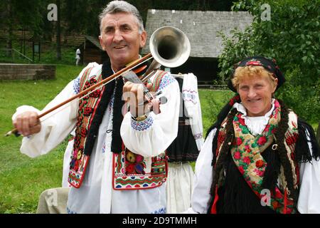 Comté de Brasov, Roumanie. Homme en costume traditionnel jouant le cor-violon roumain. Banque D'Images