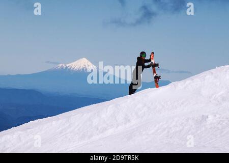 Vue sur le mont Taranaki depuis Turoa Skifield, snowboardeuse en arrière-plan, saison d'hiver, Nouvelle-Zélande Banque D'Images