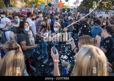 Washington, États-Unis d'Amérique. 07th nov. 2020. Une femme ouvre une bouteille de champagne tandis que les gens la vaporise dans les rues près de la Maison Blanche dans les heures qui suivent l'élection du candidat démocrate à la présidence et de l'ancien vice-président Joe Biden à Washington, DC, le samedi 7 novembre 2020. Credit: Rod Lamkey/CNP | usage dans le monde crédit: dpa/Alay Live News Banque D'Images