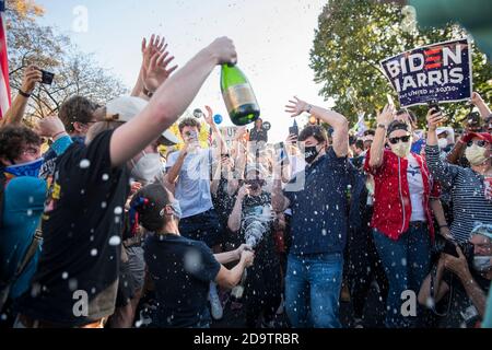Washington, États-Unis d'Amérique. 07th nov. 2020. Une femme ouvre une bouteille de champagne tandis que les gens la vaporise dans les rues près de la Maison Blanche dans les heures qui suivent l'élection du candidat démocrate à la présidence et de l'ancien vice-président Joe Biden à Washington, DC, le samedi 7 novembre 2020. Credit: Rod Lamkey/CNP | usage dans le monde crédit: dpa/Alay Live News Banque D'Images