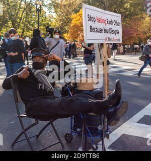 Washington DC, Etats-Unis 11/06/2020: Un homme afro-américain âgé est assis à côté d'une bannière qui dit "se hait en train de se manger parce que vous n'êtes pas d'accord" A n Banque D'Images