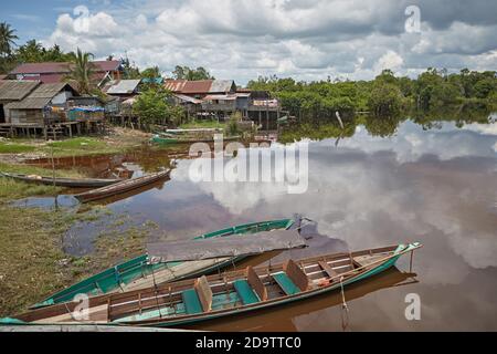 Palangka Raya, Kalimantan, Indonésie, février 2016. Canoës devant des maisons en bois construites sur la rivière à la périphérie de la ville. Banque D'Images