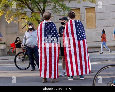 Washington, DC, Etats-Unis, 7 novembre 2020. En photo : beaucoup de gens portaient des drapeaux américains, y compris ce couple sur la place McPherson, pour célébrer la victoire de Biden Harris à l'un des plus grands partis de rue de l'histoire de la ville majoritairement démocrate. Des milliers de Washingtoniens et de partisans de Biden / Harris sont venus à la Maison Blanche / Black Lives Matter Plaza et à d'autres endroits du centre-ville pour célébrer la victoire de Biden sur Trump et l'élection de la première vice-présidente féminine dans l'histoire du pays. Crédit : Allison C Bailey/Alay Live News Banque D'Images