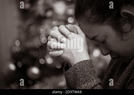 Une image en noir et blanc du concept. Une femme asiatique s'accroche à Dieu avec ce qu'elle souhaite pour la guérison. Tristesse, douleur, espoir et amour dans le bokeh Banque D'Images