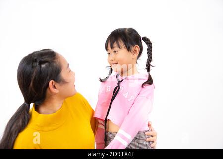 La photo des enfants asiatiques tenant la main avec leurs filles et racontant l'amour dans un fond blanc. Banque D'Images