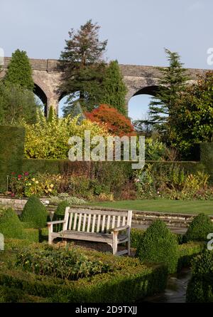 Kilver court Gardens, banc dans le jardin historique au bord du lac à Shepton Mallet, Somerset, au Royaume-Uni, photographié en automne avec des feuilles sur les arbres qui se colorent Banque D'Images