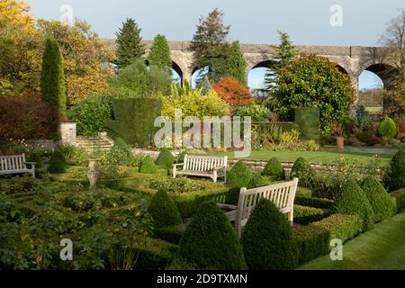 Kilver court Gardens, banc dans le jardin historique au bord du lac à Shepton Mallet, Somerset, au Royaume-Uni, photographié en automne avec des feuilles sur les arbres qui se colorent Banque D'Images