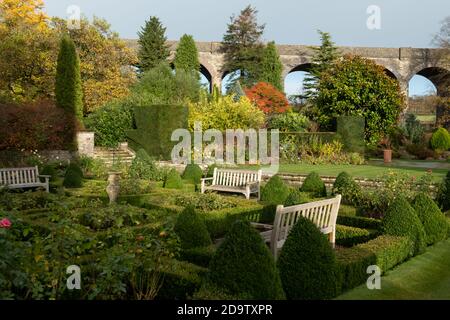 Kilver court Gardens, banc dans le jardin historique au bord du lac à Shepton Mallet, Somerset, au Royaume-Uni, photographié en automne avec des feuilles sur les arbres qui se colorent Banque D'Images