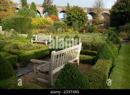 Kilver court Gardens, banc dans le jardin historique au bord du lac à Shepton Mallet, Somerset, au Royaume-Uni, photographié en automne avec des feuilles sur les arbres qui se colorent Banque D'Images