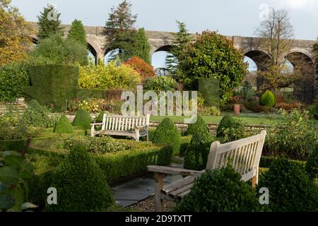 Kilver court Gardens, banc dans le jardin historique au bord du lac à Shepton Mallet, Somerset, au Royaume-Uni, photographié en automne avec des feuilles sur les arbres qui se colorent Banque D'Images