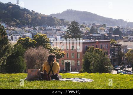 San Francisco, Californie, Etats-Unis - MARS 15 2019: Une fille se détendant sur un pique-nique dans Alamo Square Park par une journée ensoleillée Banque D'Images