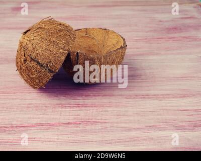 coque vide de noix de coco. pièces de coque de noix de coco sur fond rouge en bois, cosmétiques et déchets zéro production, copie de l'espace. Banque D'Images
