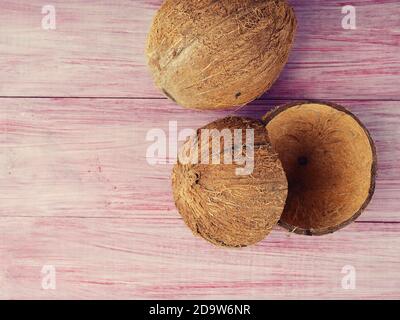 coque vide de noix de coco. pièces de coque de noix de coco sur fond rouge en bois, cosmétiques et déchets zéro production, copie de l'espace. Banque D'Images