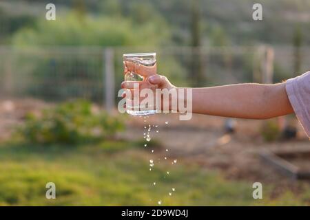 une fille déborde d'eau du verre Banque D'Images