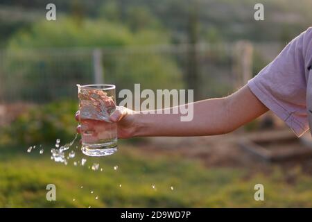 une fille déborde d'eau du verre Banque D'Images