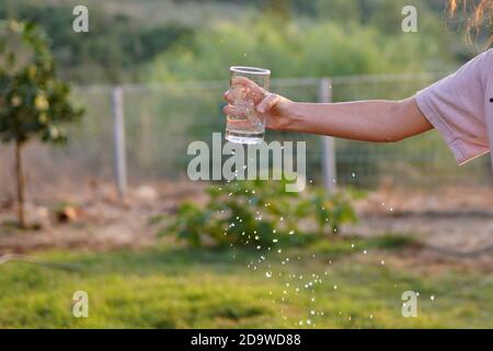 une fille déborde d'eau du verre Banque D'Images