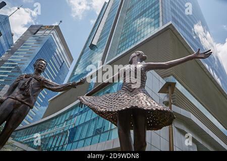 Jakarta, Indonésie, mars 2016. Sculptures en bronze de danseurs dans le centre-ville, avec des gratte-ciels en arrière-plan. Banque D'Images