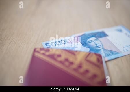 Coin d'un projet de loi de cinquante mille roupies partiellement à l'intérieur d'un Passeport suédois Banque D'Images