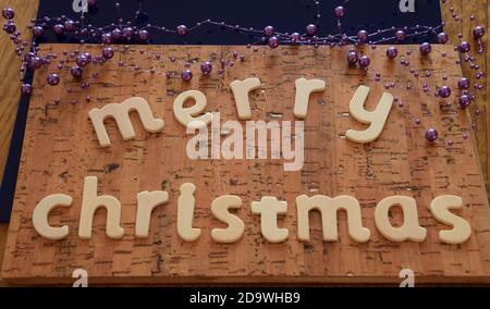 lettres de noël en bois sur fond de liège et chaîne colorée concept noël heure Banque D'Images